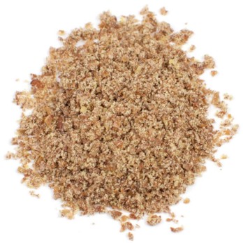 Image shows a circle of golden coloured flax meal that looks like sand on a white background