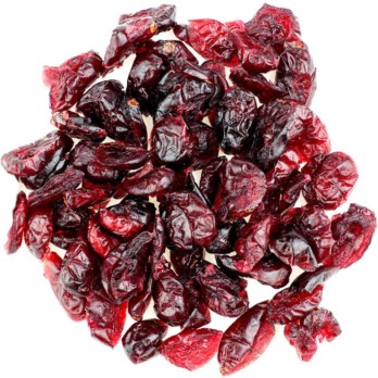 Image shows a small circle of dark red shiny cranberries piled on a white background