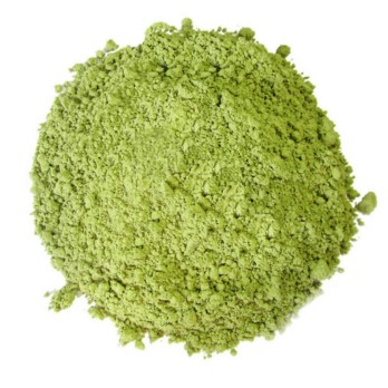 Image shows a small circular pile of green matcha tea powder on a white background