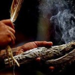 Indigenous ceremonial smudging using a feather and sage bundle
