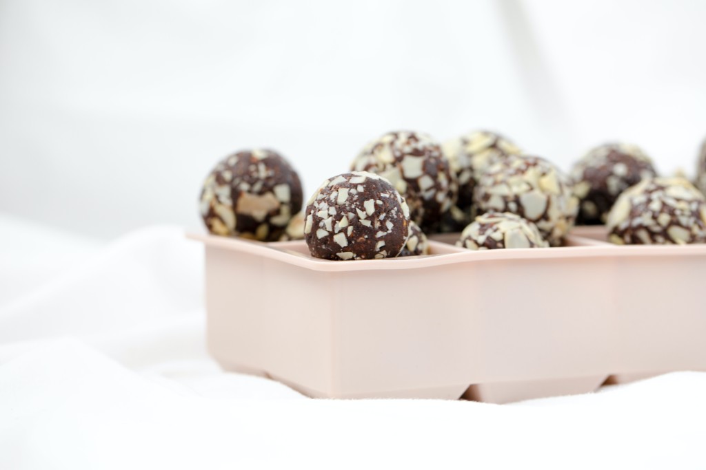 Keto double chocolate peanut butter bliss balls rolled in coconut pieces